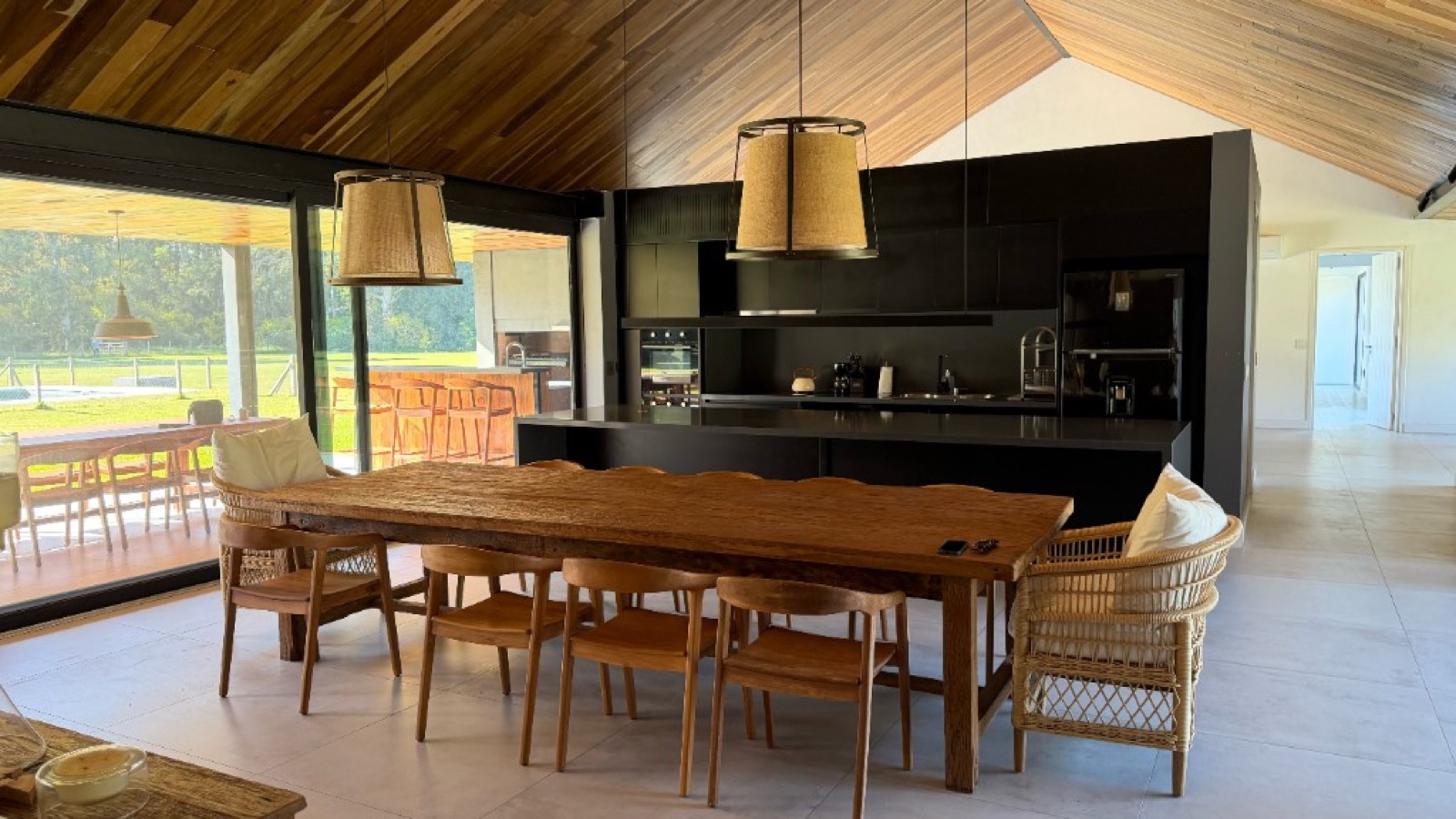 Cocina integrada y comedor con techo de madera
